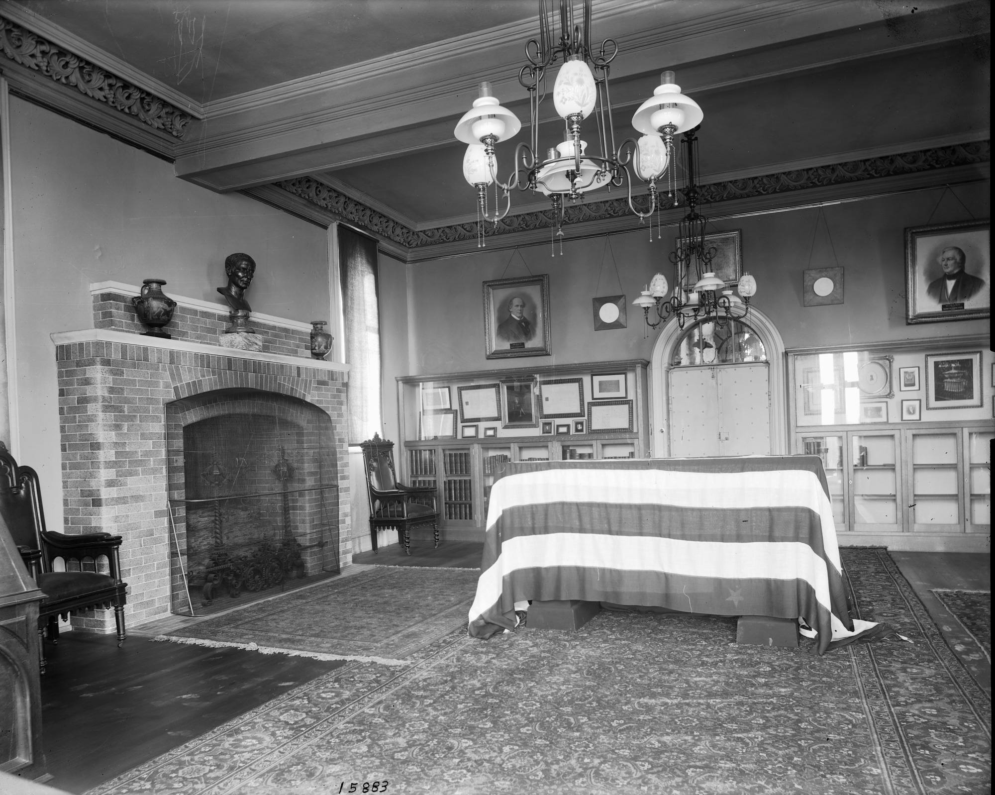 Casket draped with an American flag in a room with a fireplace