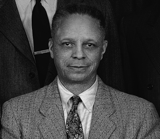 Black-and-white photo of a man looking directly at the camera