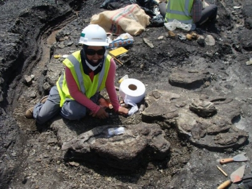 woman with fossil at field site