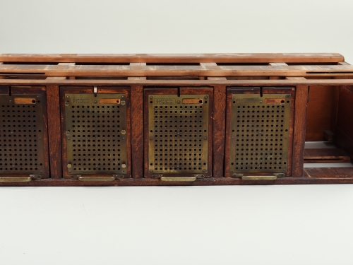 Wooden filing cabinet with four closed openings, one open.