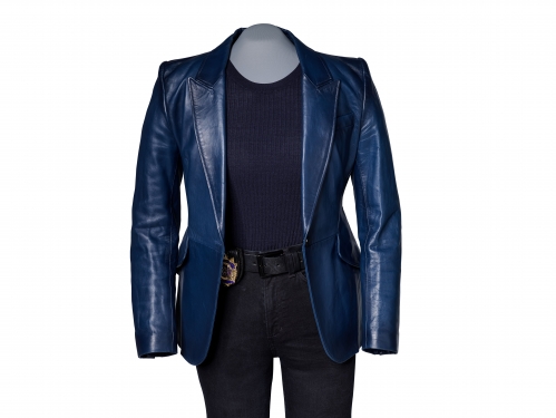 Image of an outfit on mannequin, blue leather jacket over black top and jeans with police badge at waist.