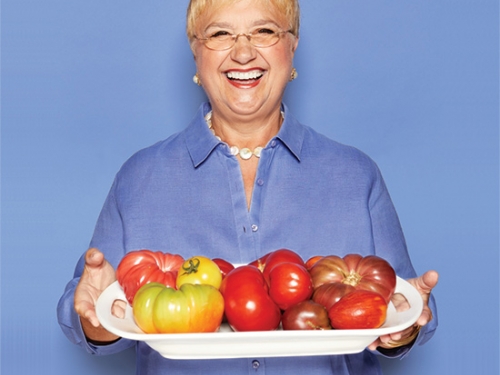 Smiling woman holding tray of fruit