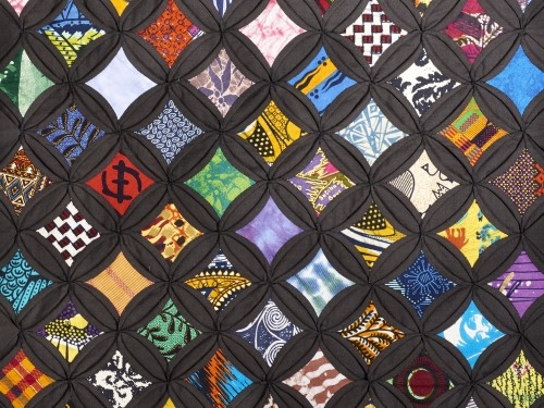 A quilt with colored squares with a black outline.