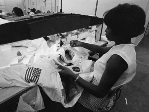 A woman sews a spacesuit for NASA.