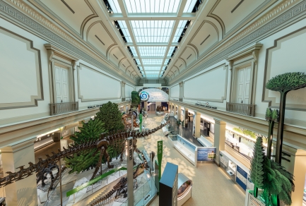 Overhead view of museum gallery with large skylight above lifesize models of dinosaurs and informational panels.