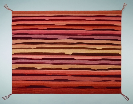 Image of flat tapestry with horizontal stripes in varying shades of orange, yellow, pink and red.