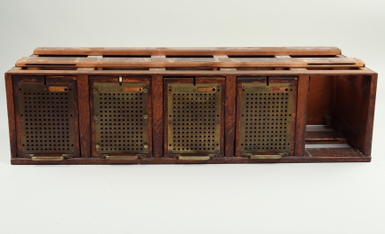 Wooden filing cabinet with four closed openings, one open.