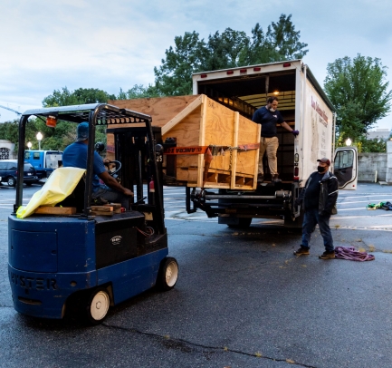 Box being loaded onto truck with small machinery